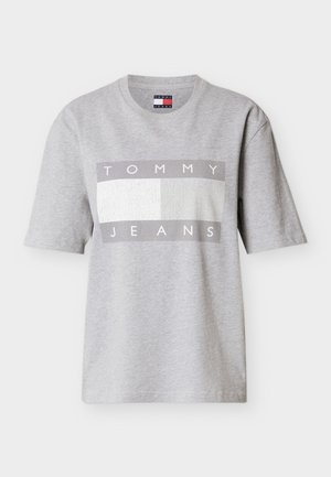 Pilkas trumpomis rankovėmis medvilninis marškinėlis su stačiakampiu grafiniu elementu, kuriame baltomis raidėmis užrašyta „TOMMY“, o pilkais – „JEANS“, ant tekstūruoto fono.