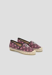 Espadrillas in tessuto rosa con un motivo geometrico nero, bordi neri e un accento a forma di logo rotondo sul davanti, con suola in corda di juta.