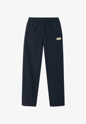 Temno modre trenirke z elastičnim pasom, zoženimi hlačnicami in rumenim logotipom na levi stegni; izdelane iz mehke mešanice bombaža.