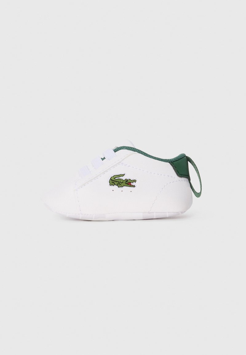 Scarpa da neonato bianca con punta arrotondata, dettagli verdi nel tallone e nei lacci, e logo di coccodrillo ricamato verde sul lato.