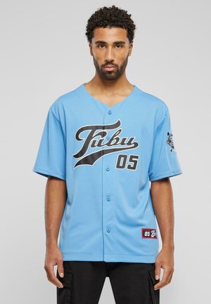 Lysblå baseballtrøje med sort logo og "05" bogstaver. Har knapfront, korte ærmer og et mærke på kanten.