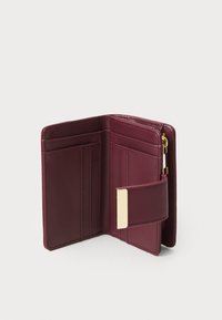 Portofel din piele bordo cu multiple sloturi pentru carduri, un compartiment cu fermoar și un detaliu de închidere de culoare aurie. Textură netedă și design compact.