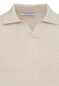 Polo en maille beige avec une texture douce, doté d'un col ouvert et d'une étiquette Felix Hardy taille M à l'intérieur de l'encolure.