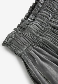 Svart plisserad tyg med en glänsande yta, elastisk midjeband detaljerad med samlad tyg, som visar en mjuk, flödande design.