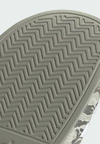 La suola delle sneakers a motivo camouflage presenta una superficie in gomma grigia testurizzata con un design a zigzag per garantire trazione.