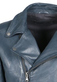Chaqueta de motocicleta de cuero azul con un cuello afilado, herrajes plateados y cierre lateral con cremallera. Textura suave con un acabado liso.