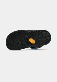 Laste kinga must tekstuuriga kummitald, millel on kolmnurkse muster ja oranž Vibram'i logo keskel.