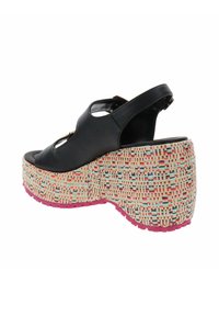 Sandaletta nera in pelle con tacco wedge e punta aperta, dotata di una suola in juta intrecciata decorata e una suola in gomma rosa. Include una cinghia regolabile alla caviglia.