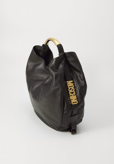 Geantă din piele neagră cu un design lejer, mâner în ton auriu și logo-ul embosat "MOSCHINO" pe lateral. Textură netedă și formă structurată.