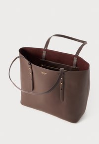 Brown leather tote bag with a smooth exterior and suede-like maroon interior. Features dual handles and gold-tone hardware accents.