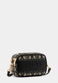 Borsa in tessuto nera e beige con motivo, dotata di hardware dorato. Presenta dettagli del logo e chiusura con zip. Forma rettangolare e tracolla regolabile.