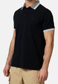 Schwarzes Poloshirt mit einem strukturierten grauen Kragen, drei Knöpfen und gestreiften Akzenten an den Ärmeln. Weicher Stoff mit figurbetontem Design.