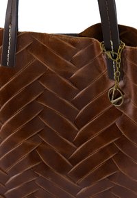 Brown leren tote bag met een geweven patroon, donkere handvatten en een metalen accentketting met een decoratieve sluiting. Gladde textuur.