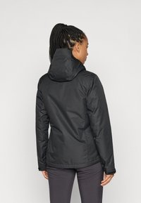 Veste noire isolée avec capuche, présentant un extérieur lisse et des poignets élastiques. Le dos montre un design légèrement cintré à la taille.