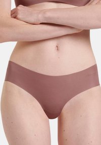 Slip senza cuciture a vita bassa in un delicato tono di malva, realizzato in tessuto morbido con una fascia elastica che presenta un discreto dettaglio del logo.