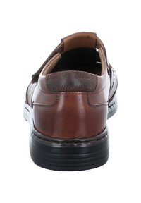 Brązowy skórzany but o fasonie slip-on, gładkiej fakturze, przeszyciach oraz czarnej gumowej podeszwie dla trwałości.