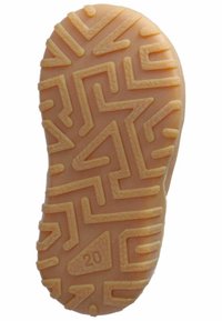 Suola di scarpa in gomma di un beige chiaro con un motivo a zigzag testurizzato e forma arrotondata, etichettata con il numero 20.