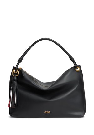 Sac à main en cuir noir avec poignée tressée, anneaux dorés, pompon multicolore et petit logo Tommy Hilfiger doré sur le devant.