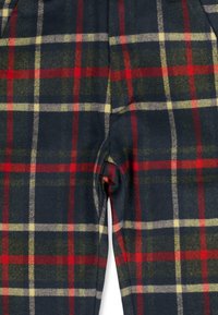 Pantalon à carreaux en tissu doux, présentant une base marine avec des motifs à carreaux rouges, verts et jaunes ; coupe slim avec un design sur mesure.