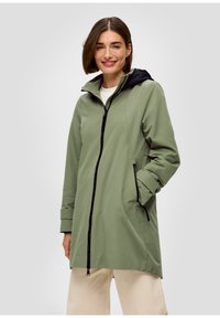 Veste imperméable verte avec une capuche noire, fermeture éclair à l'avant, poches latérales et poignets. Présente une coupe droite et une texture légère.