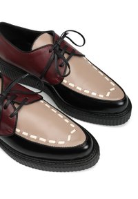 Bordowe buty skórzane w dwóch kolorach z beżowym przodkiem z detalami w postaci przeszyć oraz czarną, teksturowaną podeszwą.