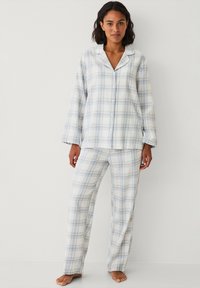 Geruite katoenen pyjama set met een knoopsluiting shirt met kraag en lange mouwen, en bijpassende broek. Kleuren zijn wit, blauw en grijs.