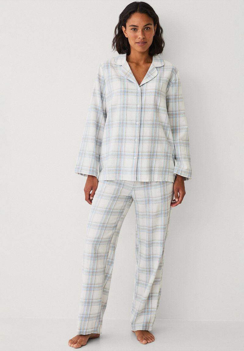 Geruite katoenen pyjama set met een knoopsluiting shirt met kraag en lange mouwen, en bijpassende broek. Kleuren zijn wit, blauw en grijs.