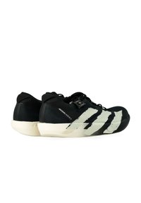 Un paio di scarpe da corsa Adidas Adizero Adios 9, nere e bianche, con lacci neri e suole bianche, viste di lato su uno sfondo bianco.