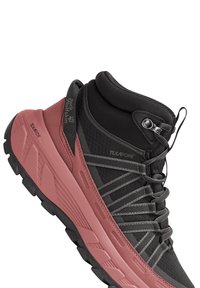 Schwarzer und pinker wasserdichter Wanderschuh mit strukturiertem Obermaterial, Schnürsystem, gepolstertem Kragen und robustem Profil, das für Traktion sorgt.