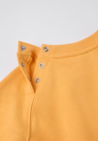 Geel katoenen kledingstuk met een geribde halslijn en twee drukknoopsluitingen bij de kraag. Soepele textuur met een vereenvoudigd ontwerp.