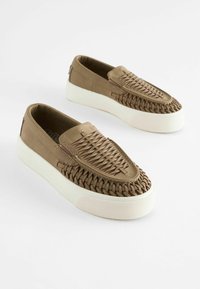 Brune slip-on sko med vævet overdel, hvid gummisål og en struktureret finish. Har en rund tå og et minimalistisk brandingelement.