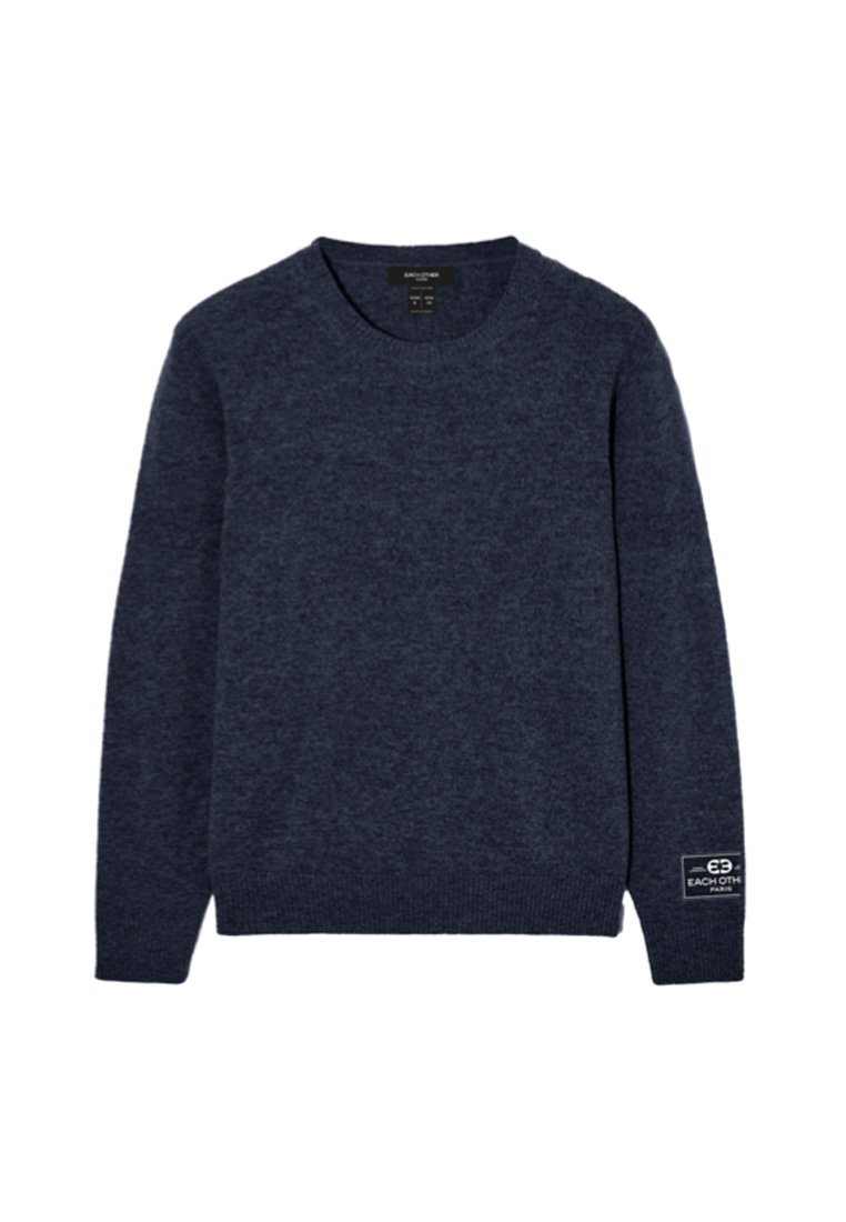 Granatowy sweter z okrągłym dekoltem, uszyty z miękkiego materiału, z prążkowanymi mankietami i dołem, z małą naszywką marki na dolnym lewym rękawie.