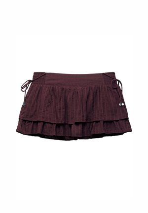 Jupe superposée bordeaux avec un design froncé, dotée d'une taille smockée et de côtés à cordons pour un ajustement réglable. Tissu texturé.