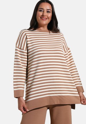 Striped sweater in tan and white, featuring a loose fit, long sleeves, and a textured knit. Hemline is longer at the back.