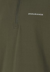 Olivgrön polo t-shirt med halv dragkedja, med en slät yta och logotypen "ENDURANCE" i vitt på bröstet.