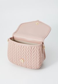 Ροζ πλεκτή τσάντα σε μαλακό δέρμα με στρογγυλό σχήμα, διαθέτει χρυσό κούμπωμα και ευρύχωρο εσωτερικό.