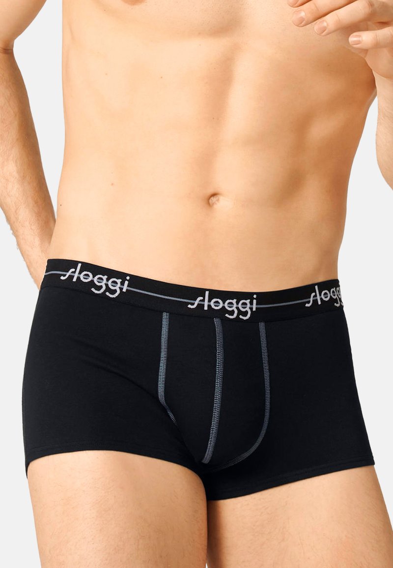 Schwarze Baumwoll-Boxershorts mit grauem Nähten und einem elastischen Bund mit "sloggi"-Logo. Mittlere Oberschenkel-Länge, glatte Textur.