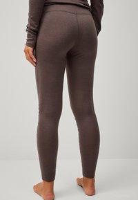 Bruine legging gemaakt van zacht materiaal, heeft een aansluitend ontwerp met een hoge tailleband en een gladde textuur zonder patronen of accenten.