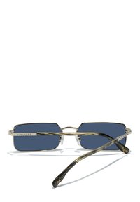 Lunettes de soleil à monture métallique avec des verres rectangulaires bleu marine. Plaquettes de nez transparentes et branches en écaille sombre à motif. Logo gravé sur la monture.