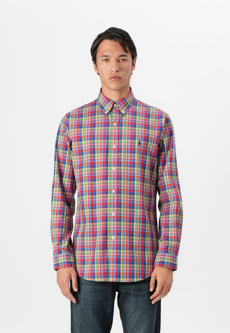 Koszula zapinana na guziki z wielokolorowym wzorem w kratę w odcieniach czerwonym, zielonym, niebieskim i żółtym. Wykonana z lekkiego materiału, z kołnierzykiem i długimi rękawami.