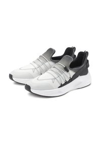 Weiße und graue Sportschuhe mit einem Obermaterial aus Mesh, elastischen Riemen über dem Spann und einer klobigen weißen Sohle. Schwarze Akzente an der Ferse.