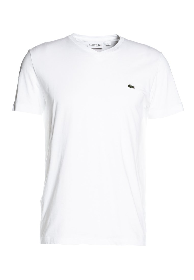 T-shirt en coton blanc avec un décolleté en V. Présente un petit logo vert Lacoste sur la poitrine gauche. Manches courtes et coupe classique.