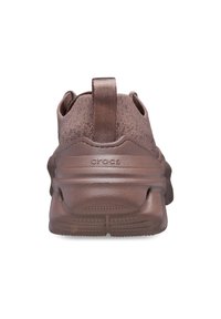 Brązowe trampki Crocs z miękką tekstylną cholewką, teksturowaną gumową podeszwą oraz pętelką z tyłu dla ułatwienia zakładania.