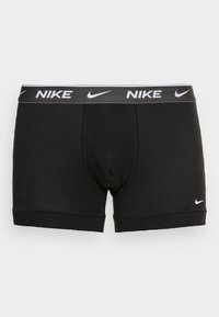 Boxeri din bumbac negru cu un tiv gri, având branding alb Nike. Textură netedă și design ajustat, cu detalii de cusătură întărită.
