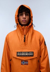Orange pullover jacket with a front pouch pocket, zip closure, adjustable hood, and branded patch featuring the Norwegian flag. Waterproof material.