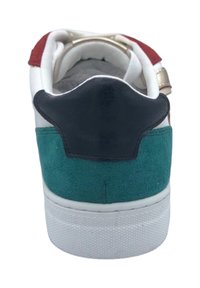 Des chaussures avec une tige en cuir blanc, un panneau en daim vert, un talon en daim noir et des accents rouges. Semelle en caoutchouc texturé. Détails en métal doré.