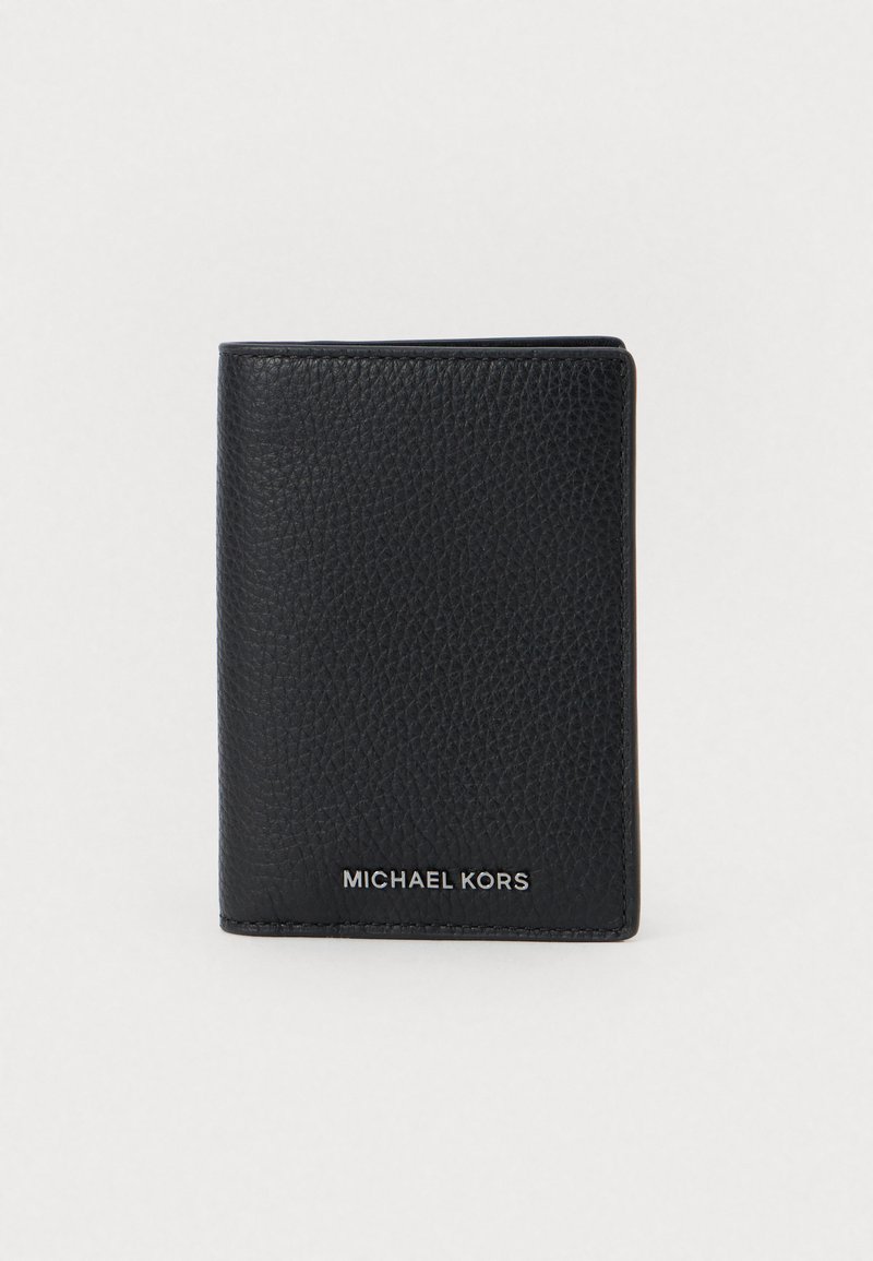 Fekete, textúrázott bőr Michael Kors bifold pénztárca, ezüst logóbetűzéssel középen az alján, fehér háttérrel.