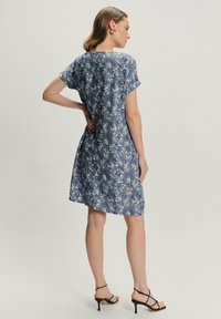 Sukienka krótko rękawowa w niebieski kwiatowy wzór, wykonana z lekkiego materiału. Silhouette A-line, do kolan, z okrągłym dekoltem i subtelną teksturą.