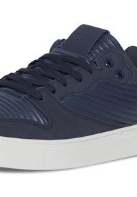 Navy blue sneakers featuring a textured synthetic upper, ribbed accents, flat laces, and a white rubber sole with a patterned grip.