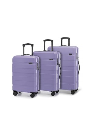 Tres maletas rígidas en un suave color lavanda, con un diseño estriado, ruedas negras y asas retráctiles.